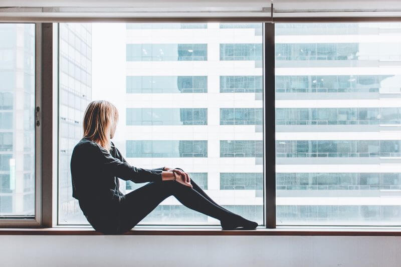 a girl looking through a glass building window